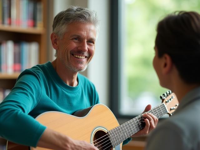 A group facilitator smiling while playing a guitar during a community session